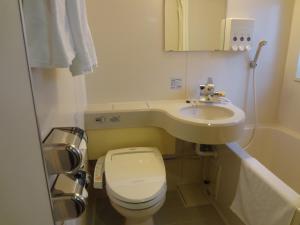 a small bathroom with a toilet and a sink at Asano Hotel in Kitakyushu