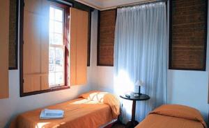 1 dormitorio con 2 camas y ventana en Pousada Solar Nossa Senhora Das Merces, en Ouro Preto