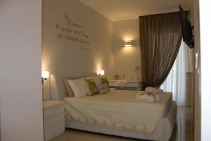 a bedroom with a bed with a sign on the wall at la dimora di Greta in Fasano