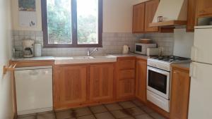 a kitchen with wooden cabinets and a white stove top oven at Le Cers in Ribaute