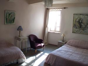 a bedroom with a bed and a chair and a window at Les chambres d'Elise in Collias