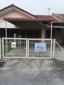 a house with a gate with a sign on it at FirZan Homestay Bukit Mahkota in Kajang