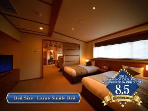 sypialnia z 2 łóżkami i telewizorem z płaskim ekranem w obiekcie Zao Kokusai Hotel w mieście Zaō Onsen