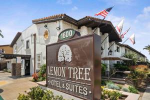 un letrero frente a un hotel y suites de árbol marrón en The Lemon Tree Hotel, en Anaheim