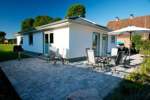 a patio with chairs and an umbrella next to a house at Ferienhaus Gammendorf in Gammendorf