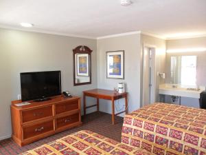 a hotel room with a bed and a flat screen tv at A-OK Motel in Muenster