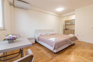 a bedroom with a bed and a table and a desk at Comfy Apartments-Ohrid in Ohrid