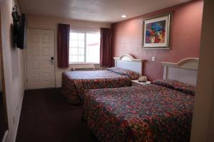 a hotel room with two beds and a window at Capri Motel Santa Cruz Beach Boardwalk in Santa Cruz