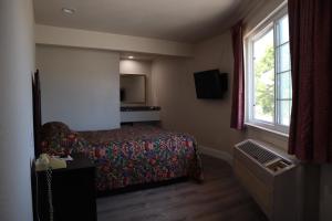 a hotel room with a bed and a window at Capri Motel Santa Cruz Beach Boardwalk in Santa Cruz