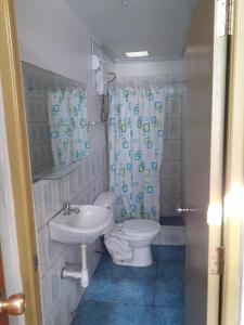 y baño con aseo y lavamanos. en Waikycha Hostal, en Arequipa
