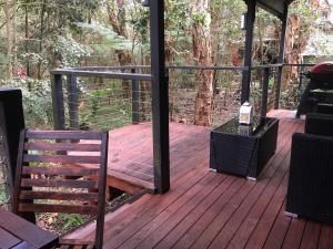 Un porche de madera con un banco en una terraza. en Wanderers Retreat, en Nelson Bay 81 fotos más