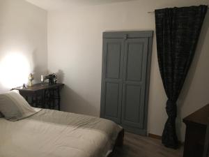 ein Schlafzimmer mit einem Bett, einem Schrank und einem Tisch in der Unterkunft La charmante **** Maison Cap Corse, Tomino in Mandolacce