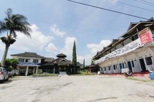 ein Gebäude mit einer Palme neben einer Straße in der Unterkunft Villa Penginapan Purnama in Bandung
