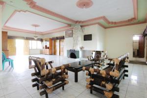 ein großes Wohnzimmer mit einem Tisch und Stühlen in der Unterkunft Villa Penginapan Purnama in Bandung