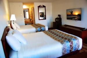 una camera d'albergo con due letti e uno specchio di Westward Inn a Crescent City