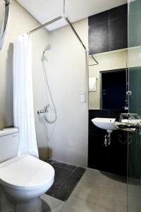 ein Bad mit einem WC, einem Waschbecken und einer Dusche in der Unterkunft Bobotel Gatot Subroto Medan in Medan