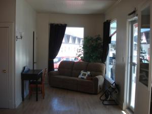 a living room with a couch and a table at Hôtel Motel du Rocher in Rivière-la-Madeleine