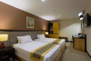 a hotel room with two beds and a television at Hallmark View Hotel in Melaka