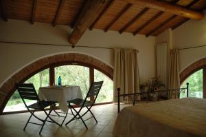 a bedroom with a table and chairs and a window at Rose Rosse in Ca' di David