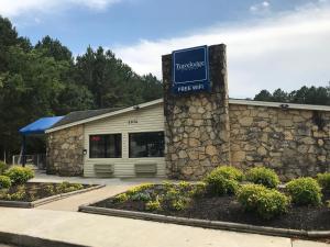 um edifício com um sinal em frente em Travelodge by Wyndham Fayetteville em Fayetteville