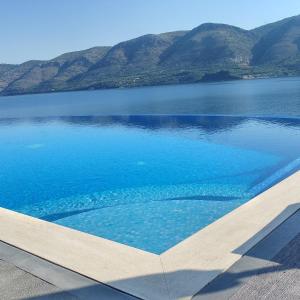 uitzicht op een meer met bergen op de achtergrond bij Blue Bay Apartments in Sivota