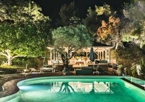 a person standing in a swimming pool at night at Sanidiamonds in Sani Beach