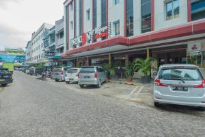 una fila de autos estacionados frente a un edificio en Paragon Nagoya Hotel Batam en Nagoya