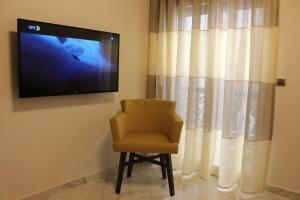 einen Stuhl vor einem Fernseher in einem Zimmer in der Unterkunft Aristotelous Forum Apartment in Thessaloniki