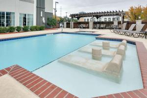 a large swimming pool with blue water in a building at La Quinta by Wyndham Dallas Love Field in Dallas