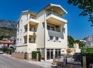 a tall white building on the side of a street at Apartments Mijo in Dugi Rat