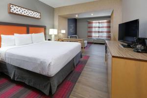 a hotel room with a bed and a flat screen tv at La Quinta by Wyndham Dallas Love Field in Dallas