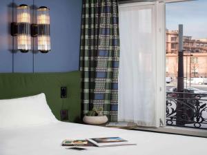 a bedroom with a bed and a window with a view at ibis Styles Paris Nation Cours de Vincennes in Paris +37 photos