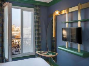 a room with a bed and a tv and a window at ibis Styles Paris Nation Cours de Vincennes in Paris