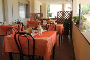 ein Restaurant mit Tischen und Stühlen mit roten Tischdecken in der Unterkunft Hotel 106 in Sellia Marina