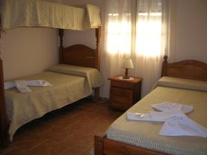 um quarto com duas camas e um candeeiro sobre uma mesa em Cabañas El Refugio de Juan em Mina Clavero
