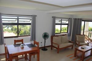 a living room with a table and chairs and windows at Island Cove in Victoria