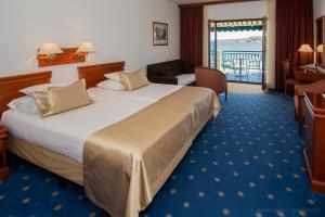 a hotel room with a large bed and a balcony at Hotel Villa Radin in Vodice