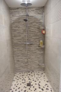 een badkamer met een douche en een tegelvloer bij Le jardin des secrets in La Voivre