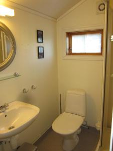 a bathroom with a white toilet and a sink at Hesthaug Gard in Eidsdal