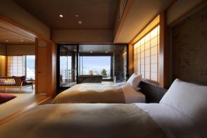 a hotel room with two beds and a balcony at Shoho in Matsumoto