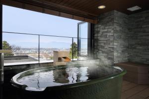 a hot tub in a room with a large window at Shoho in Matsumoto +57 photos