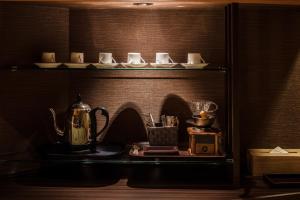 a shelf with cups and cups and a tea kettle at Shoho in Matsumoto
