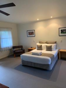 a bedroom with a large bed and a chair at Dunkeld Studio Accommodation in Dunkeld
