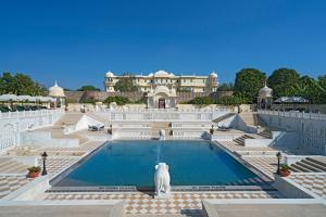 a white cat sitting in front of a swimming pool at Nahargarh Ranthambhore in Sawāi Mādhopur