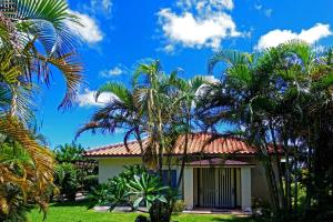 een huis met palmbomen ervoor bij Tsundara Beach Retreat in Ishigaki Island