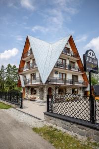 budynek z trójkątnym dachem z płotem w obiekcie Dom Wypoczynkowy Julia w mieście Białka Tatrzanska
