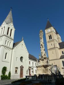 a church with two towers and a clock tower at Central Apartment in Veszprém