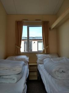 two beds in a room with a window at Swanage bay caravan in Swanage
