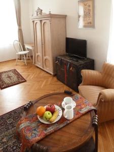 a room with a table with a plate of fruit on it at Central Apartment in Veszprém