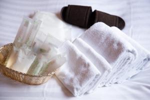 a basket filled with towels on top of a bed at THE L.A. MART HOTEL KYOTO in Kyoto